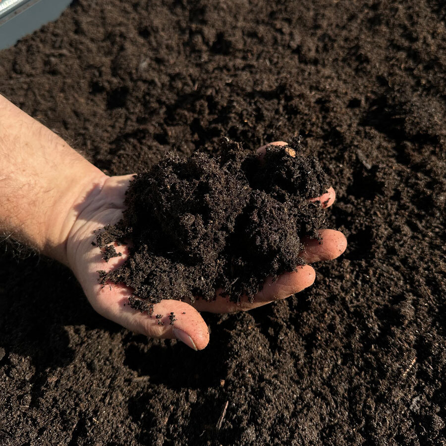 Hand mit Erde ber Gartenbeet